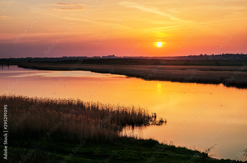 Fototapeta premium orange sunset over water in river