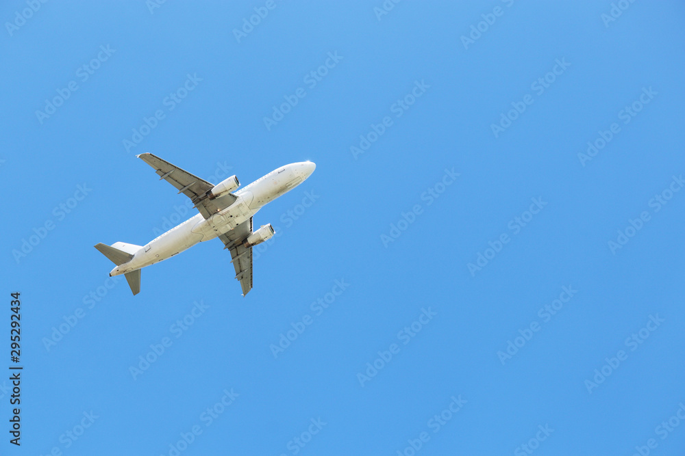 Airplane flying in the clear blue sky, bottom view. Commercial plane taking off Airplane flying in the clear blue sky, bottom view. Commercial plane taking off