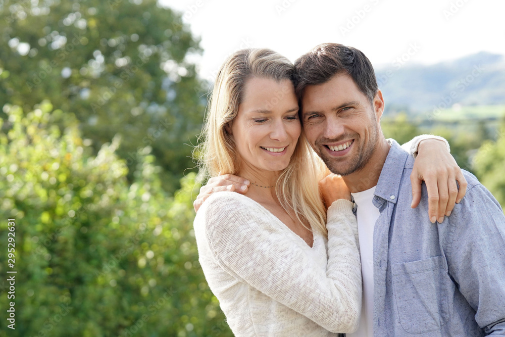 Cheerful middle-aged couple standing outside Cheerful middle-aged couple standing outside