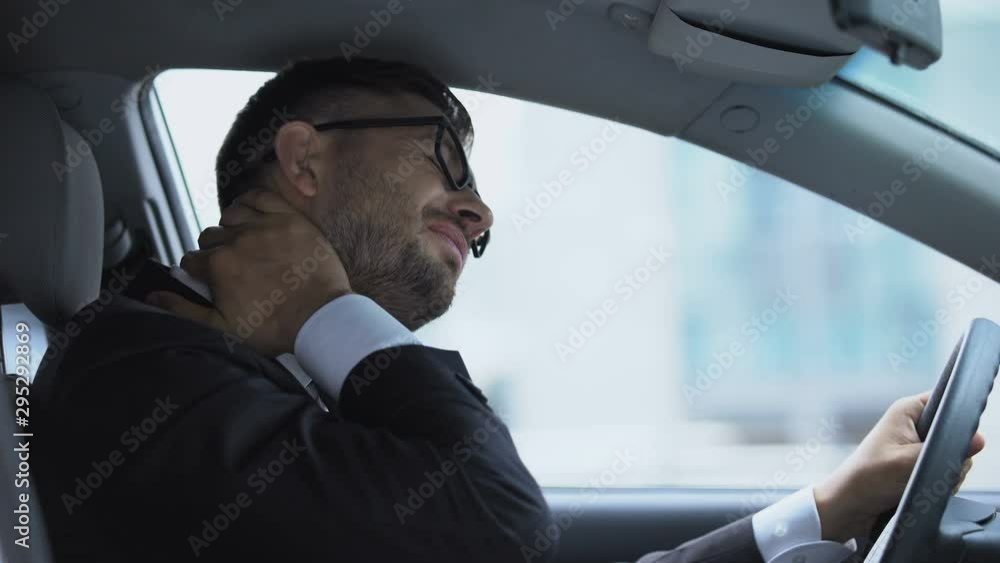 Business driver massaging numb neck sitting on driver seat, sedentary lifestyle Business driver massaging numb neck sitting on driver seat, sedentary lifestyle