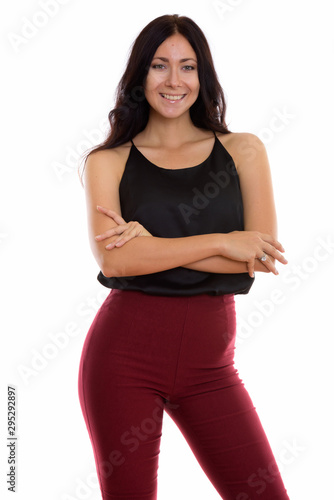 Studio shot of young happy businesswoman smiling and standing wi