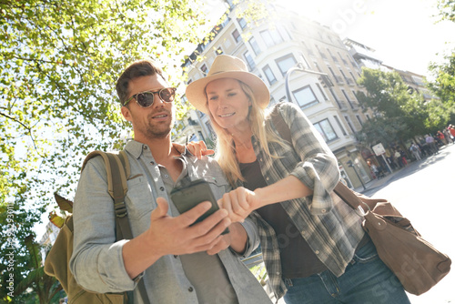 Vászonkép Tourists connected with smartphone in European city