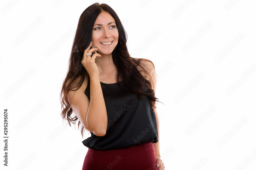 Studio shot of young happy businesswoman smiling while talking o Studio shot of young happy businesswoman smiling while talking o