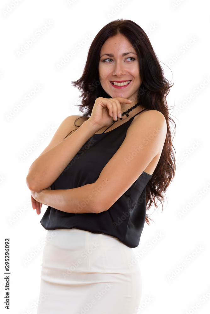 Studio shot of young happy businesswoman smiling while thinking Studio shot of young happy businesswoman smiling while thinking