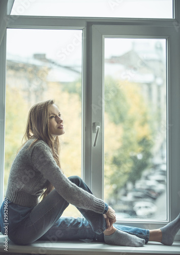 Beautiful young woman sitting by the window Free Download Beautiful young woman sitting by the window - GFXLoad