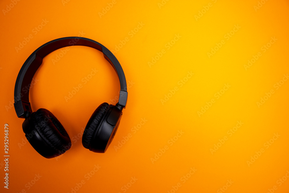 bluetooth kopfhörer auf orangenem hintergrund / headset on orange background bluetooth kopfhörer auf orangenem hintergrund / headset on orange background