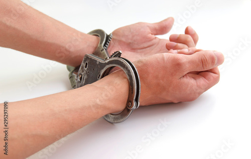 Prisoner with his hands chained isolated on white background © Анатолий Казаков