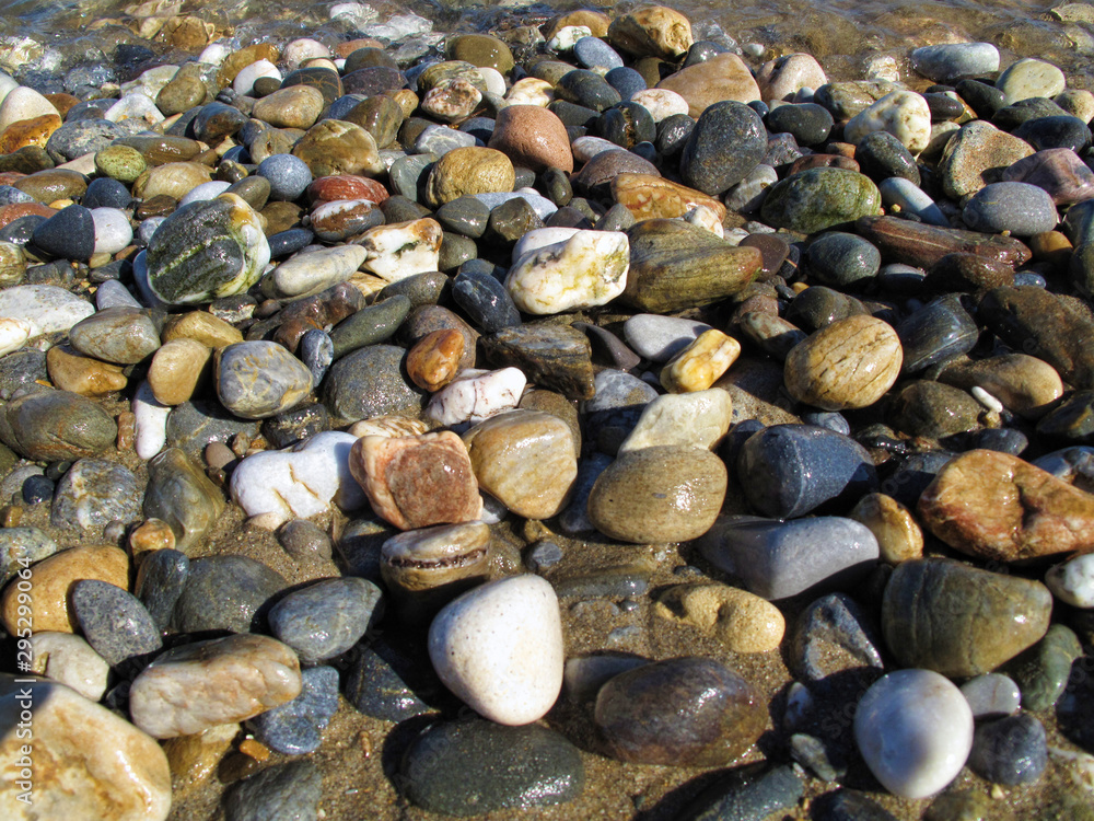 Wet different sea pebbles on the beach Wet different sea pebbles on the beach