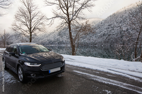 black car sedan on a background of a mountain lake in winter © Виктория Попова