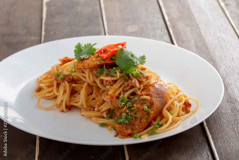 Spicy Spaghetti with Thai sausage on wood table. Spicy Spaghetti with Thai sausage on wood table.