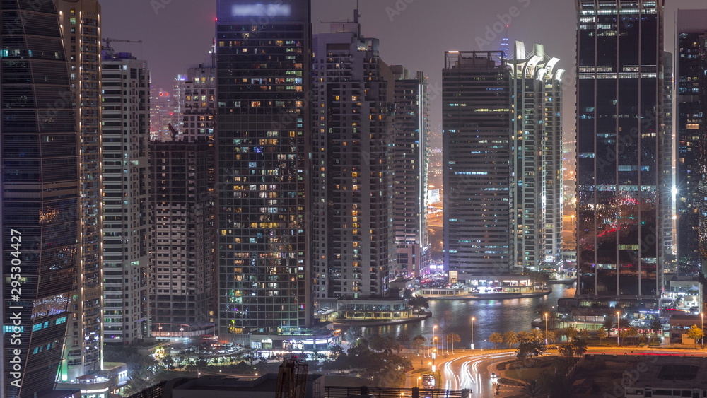 Fototapeta premium Residential and office buildings in Jumeirah lake towers district night timelapse in Dubai