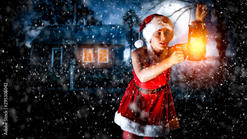 Slim young woman with lamp and christmas night 
