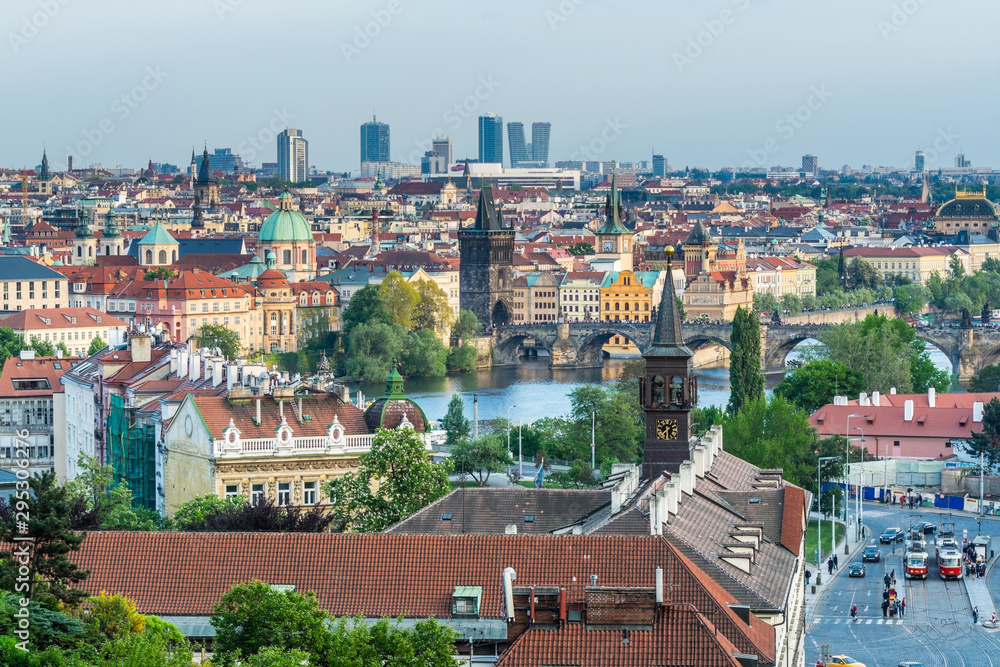 Aerial view of citycape of old town of Prague, with a lot of  rooftops, churches, and the landmark of Charles Bridge, and Vltava river. view from the Letna park.