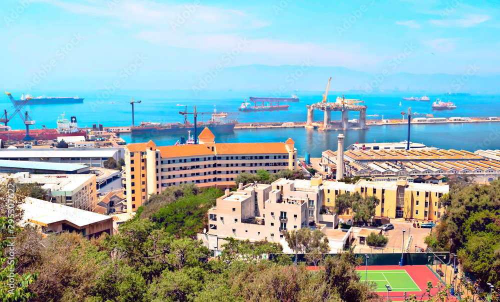 Aerial view of Gibraltar with modern buildings and the harbor with boats in the background in a sunny day