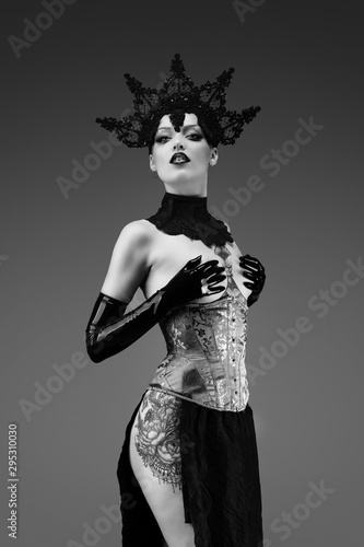 Portrait of a young woman wearing a lace cap, a corset and black latex gloves