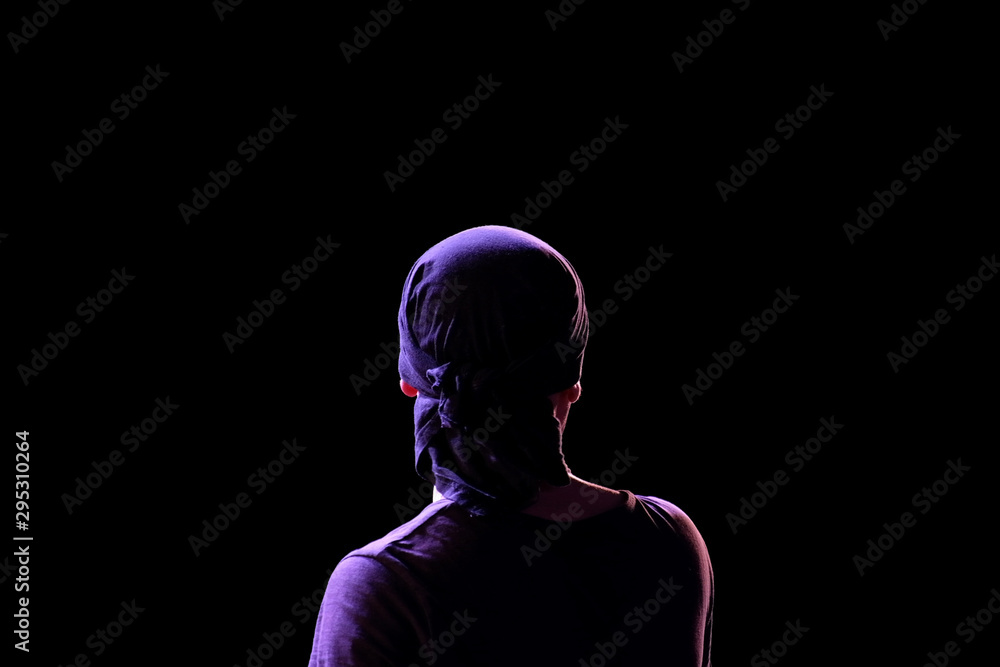 Silhouette of a guy in a dark T-shirt and bandana in back modeling light on  a black background. View of a man from the back. Isolated. Copy space.  Stock Photo | Adobe