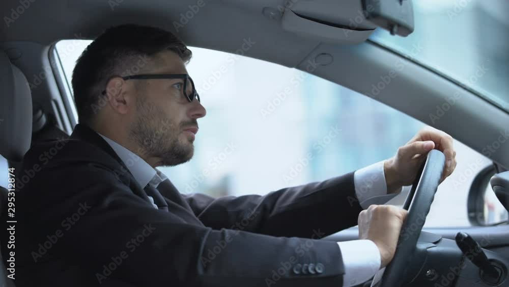 Male driver sneezing sitting in car on parking lot, seasonal allergy, virus Male driver sneezing sitting in car on parking lot, seasonal allergy, virus
