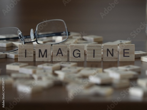 The concept of Imagine represented by wooden letter tiles photo