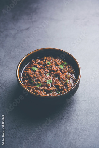 Kheema / keema Pav or Khima Paav is a spicy curry dish made up of minced chicken or lamb cooked with onion, tomatoes, served with buns. selective focus