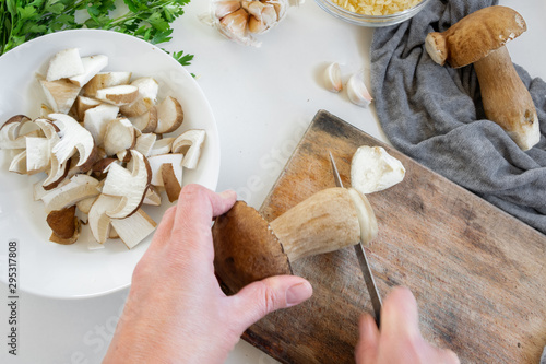 Personal perspective of woman hands preparing porcini mushrooms (Boletus edible) for cooking them