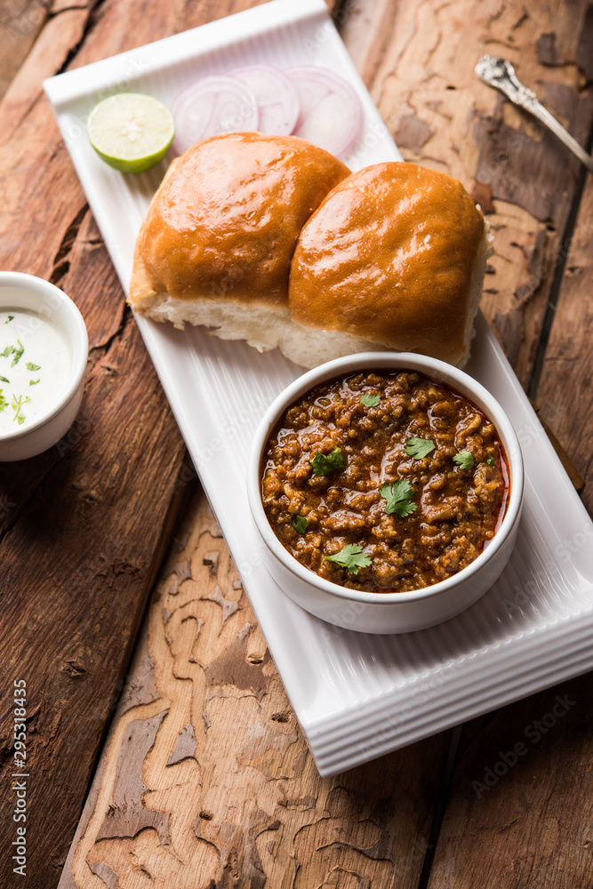 Kheema / keema Pav or Khima Paav is a spicy curry dish made up of minced chicken or lamb cooked with onion, tomatoes, served with buns. selective focus