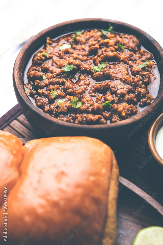 Kheema / keema Pav or Khima Paav is a spicy curry dish made up of minced chicken or lamb cooked with onion, tomatoes, served with buns. selective focus