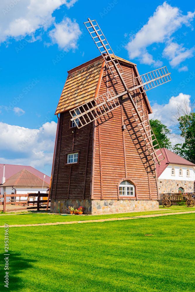 wooden windmill against blue sky in summer countryside landscape. copy space.