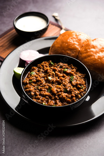 Kheema / keema Pav or Khima Paav is a spicy curry dish made up of minced chicken or lamb cooked with onion, tomatoes, served with buns. selective focus