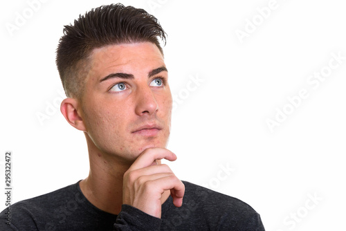 Close up of young handsome man thinking while looking up