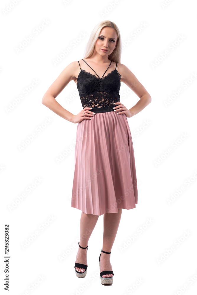Bossy displeased young woman with attitude and style holding hands on hips looking at camera. Full body isolated on white background. 