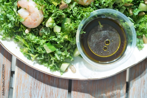 top view on herbs and spices salad with avocado and shrimps and thai siya souce on white plate photo