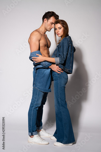 muscular man standing with attractive young woman on white
