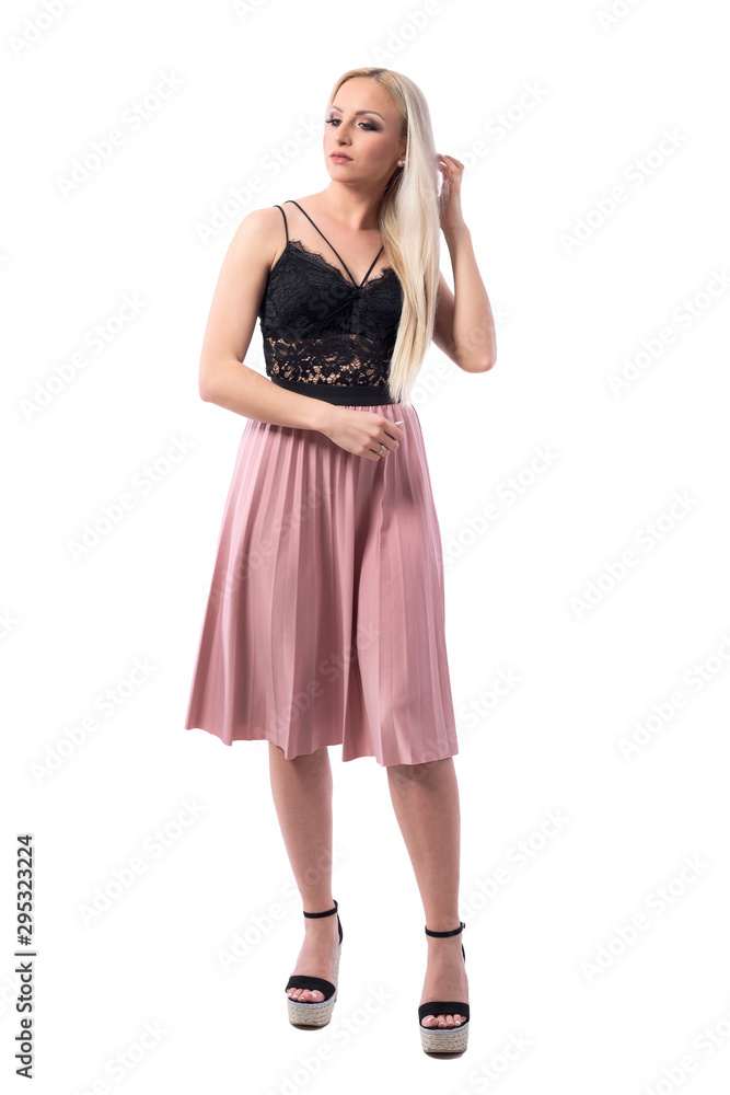 Classy feminine blonde elegant woman in skirt brushing and adjusting hair looking down. Full body isolated on white background. Classy feminine blonde elegant woman in skirt brushing and adjusting hair looking down. Full body isolated on white background.