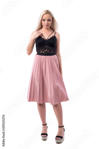 Classy young blond hair lady in elegant evening wear getting ready looking down. Full body isolated on white background. 