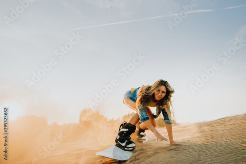 Tourist Sandboarding sexy girl In the Desert Man jumps in and does the trick