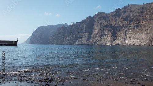 Mesmerizing views of the high cliffs of Los Gigantes or Acantilados de Los Gigantes from Playa de los Guios, giant rock formation in the western part of the island of Tenerife, Canary Islands, Spain photo