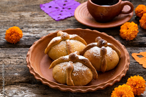 Mexican celebration, bread of death. Mexican parties with Dead bread and marigold flowers on gray stone background. Traditional Mexican Bread of the Dead Pan de Muerto . photo