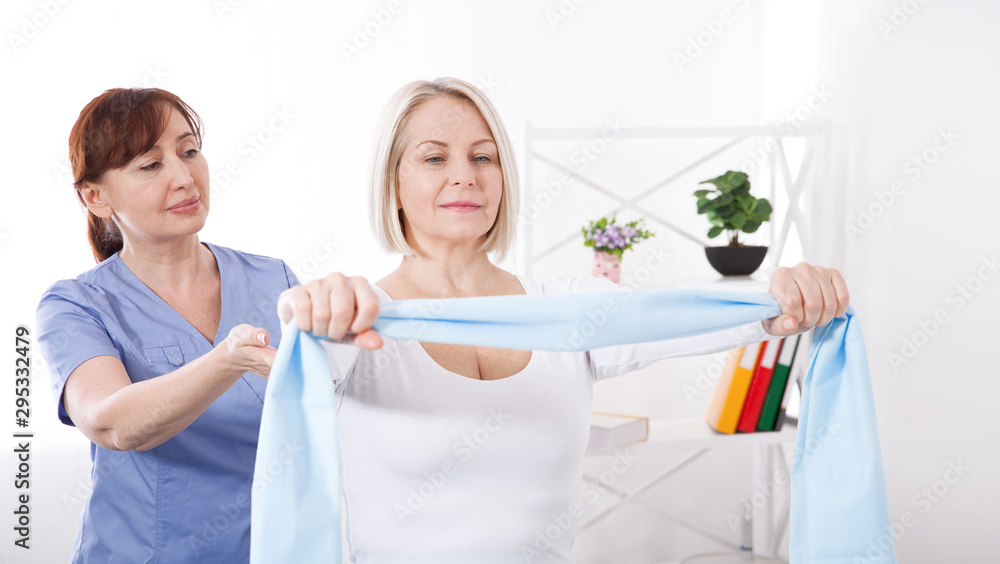 Fototapeta premium Physiotherapy, sport injury rehabilitation treatment with Resistance Band. Woman having chiropractic back adjustment. Osteopathy, Alternative medicine, pain relief concept.