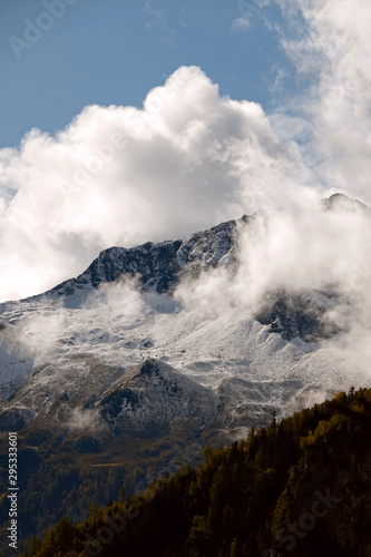 beautiful view in autumn to the alps with fresh snow and fog