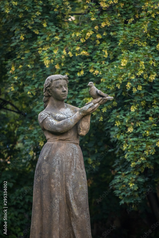 Public park stone statue Of Girl With A Pigeon. Prague, Czech republic