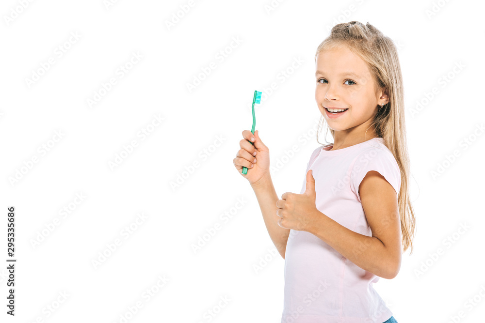 happy kid holding toothbrush and showing thumb up isolated on white happy kid holding toothbrush and showing thumb up isolated on white