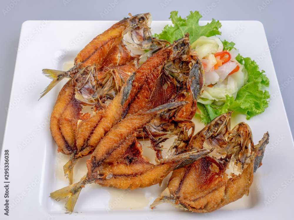 Deep fried fish on white plate, selective focus of Thai meal. Deep fried fish on white plate, selective focus of Thai meal.