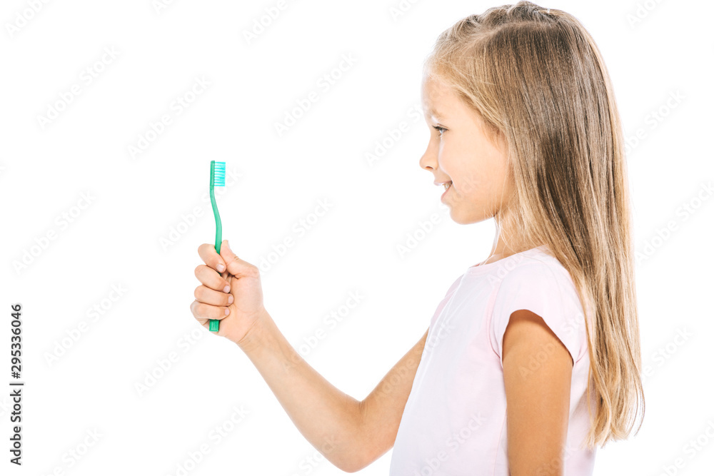 side view of kid looking at toothbrush isolated on white side view of kid looking at toothbrush isolated on white