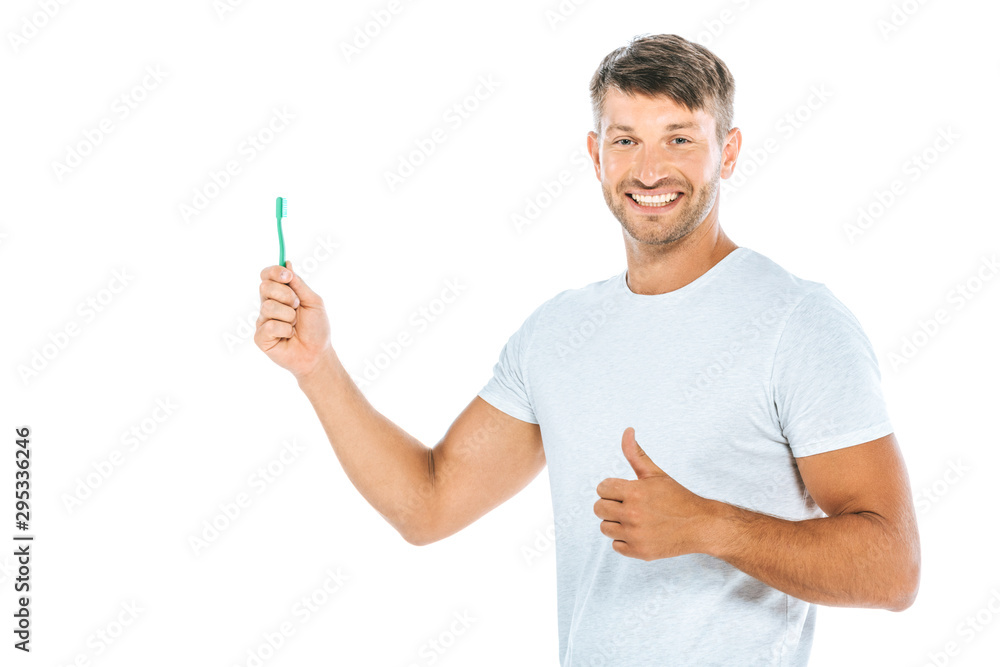 cheerful man holding toothbrush while showing thumb up isolated on white cheerful man holding toothbrush while showing thumb up isolated on white