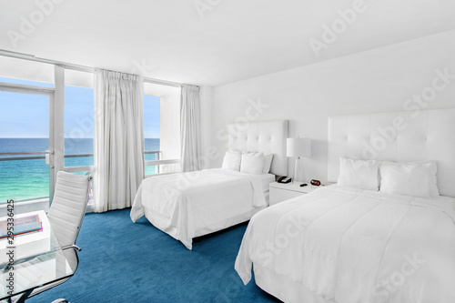 Oceanfront bedroom of luxury summer beach house with queen bed with colorful interior design