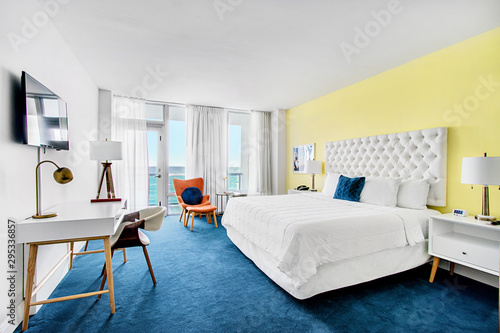 Oceanfront bedroom of luxury summer beach house with queen bed with colorful interior design