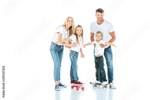 happy parents near kids riding penny boards on white
