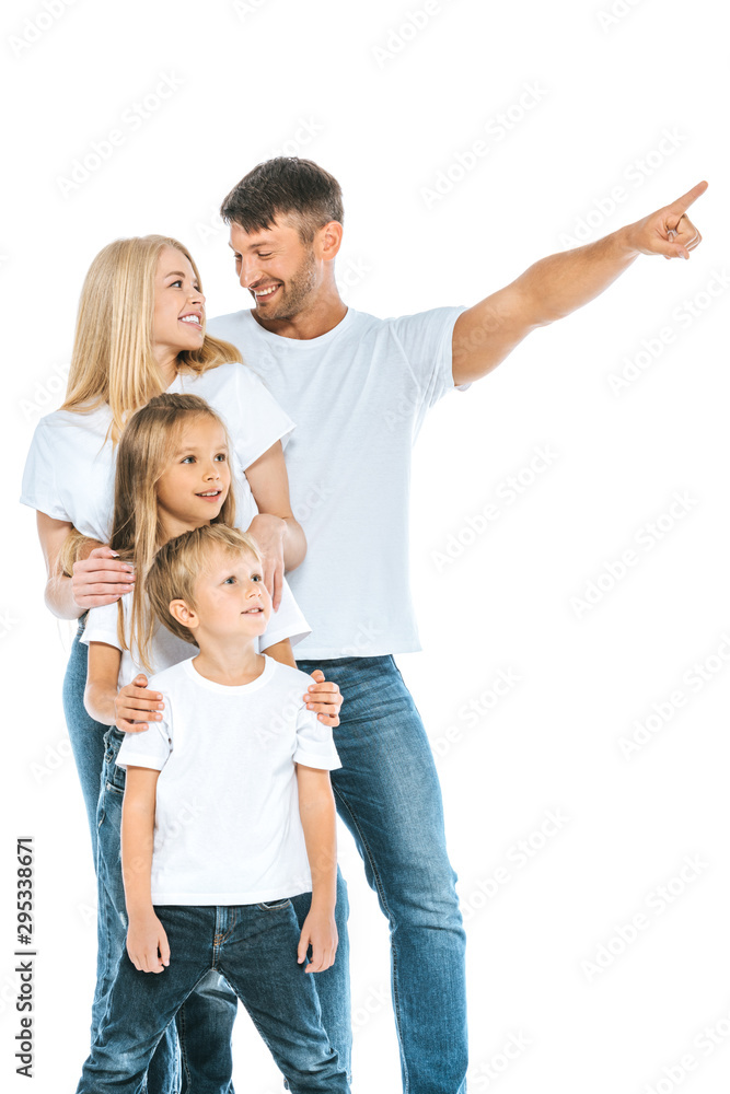 happy man looking at wife while pointing with finger near kids on white