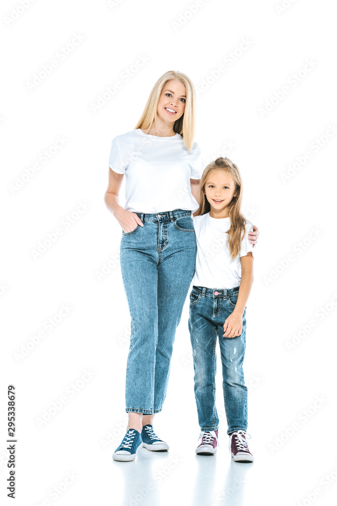 happy woman standing with hand in pocket near kid on white happy woman standing with hand in pocket near kid on white