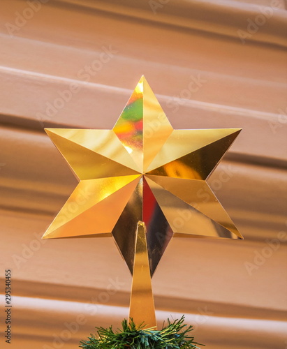 Christmas star decorates  top of  Christmas tree